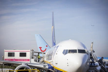 Close-up of a Ryanair Boeing 747 with passengers using stairs on the right and an ambulift at the central exit on the left.