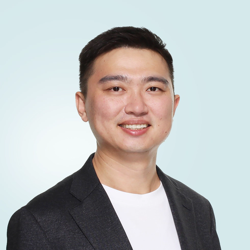 Jay Shen, an asian man with short black hair, and CEO of Transreport, in a grey suit, facing the camera.