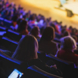 A photo of theatre-style seats in a venue packed with people.