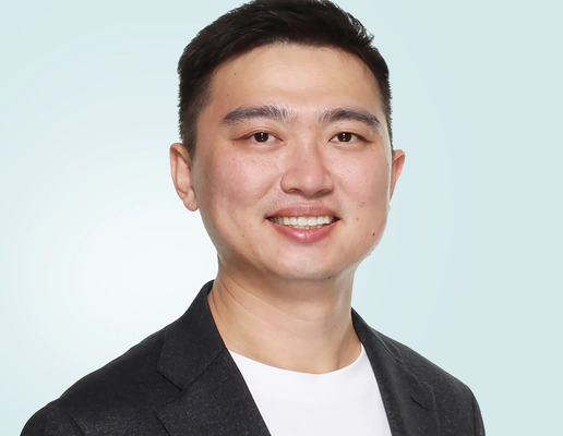 Jay Shen, an asian man with short black hair, and CEO of Transreport, in a grey suit, facing the camera.