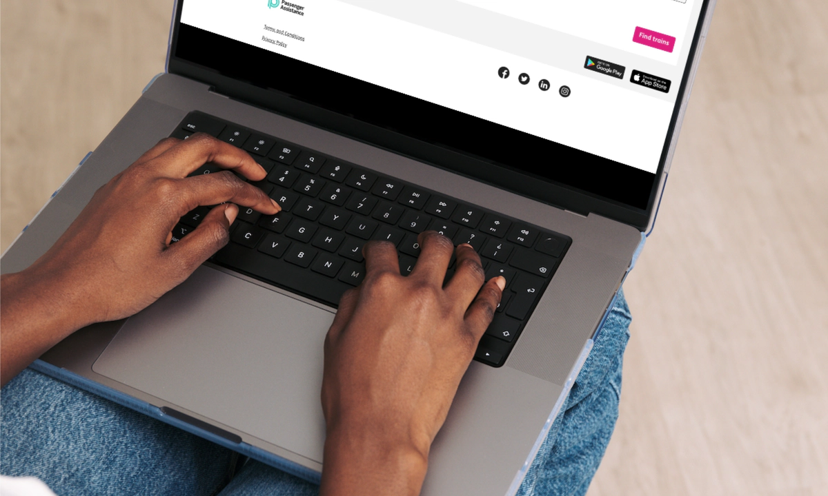 A close-up of a person using a laptop computer resting on their lap.