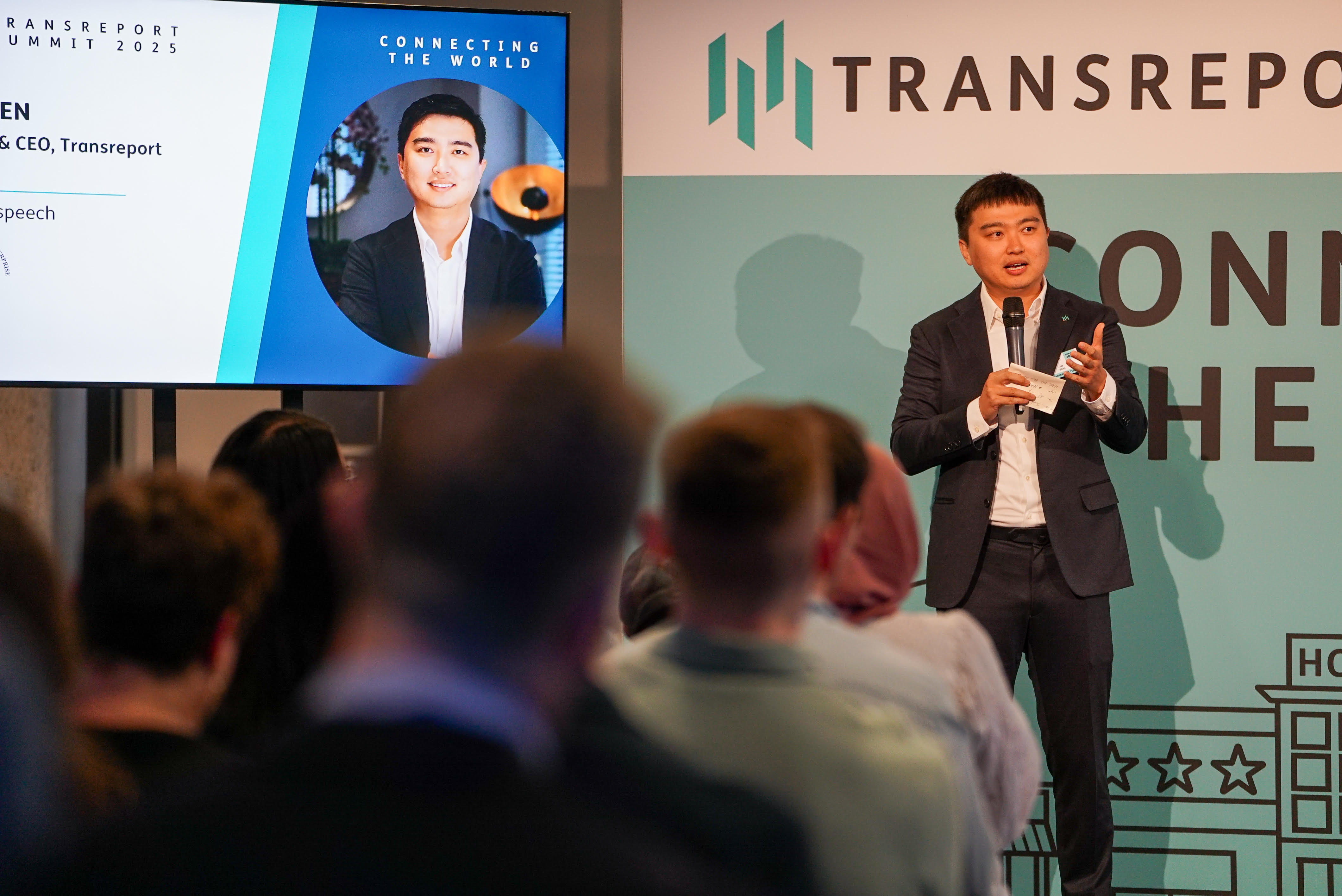 Photo of Jay Shen delivering a keynote at Transreport Summit 2025.