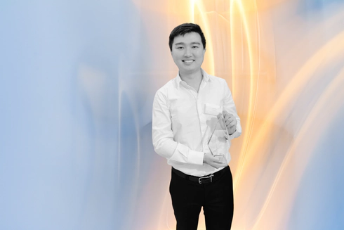 Jay Shen, an asian man with short black hair, and CEO of Transreport, smiling and holding an award.
