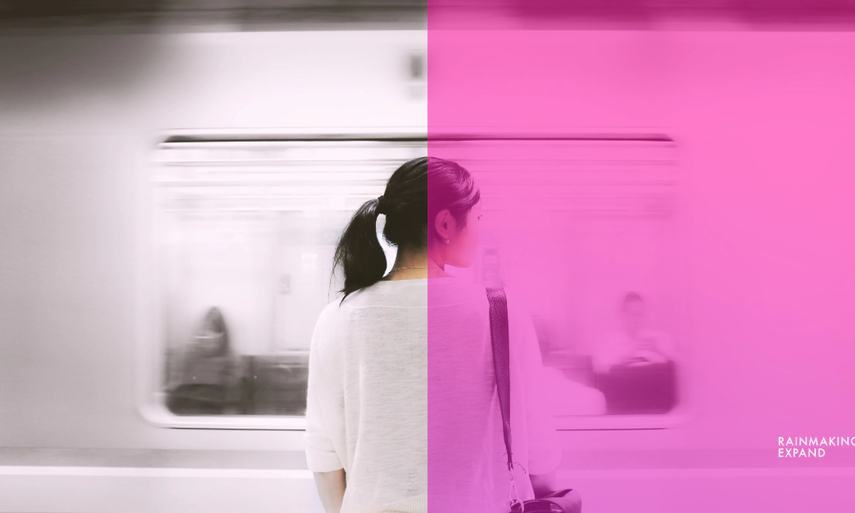 A woman standing on a platform facing a moving train. A woman standing on a platform facing a moving train.