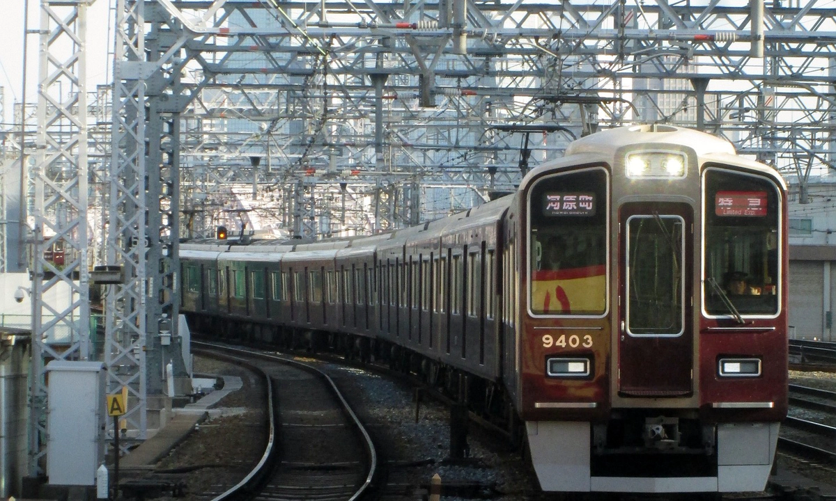 A picture of a dark red Hankyu train on the tracks at Osaka Railway Station. A picture of a dark red Hankyu train on the tracks at Osaka Railway Station.