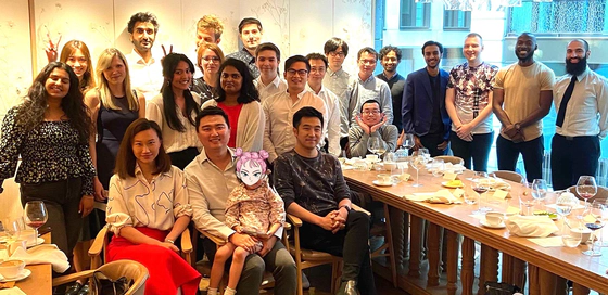 A group photo of some Transreport employees standing and sitting around a table.